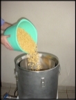 Abastecendo o cesto de ao inox com gros de soja previamente macerados (deixados de molho)